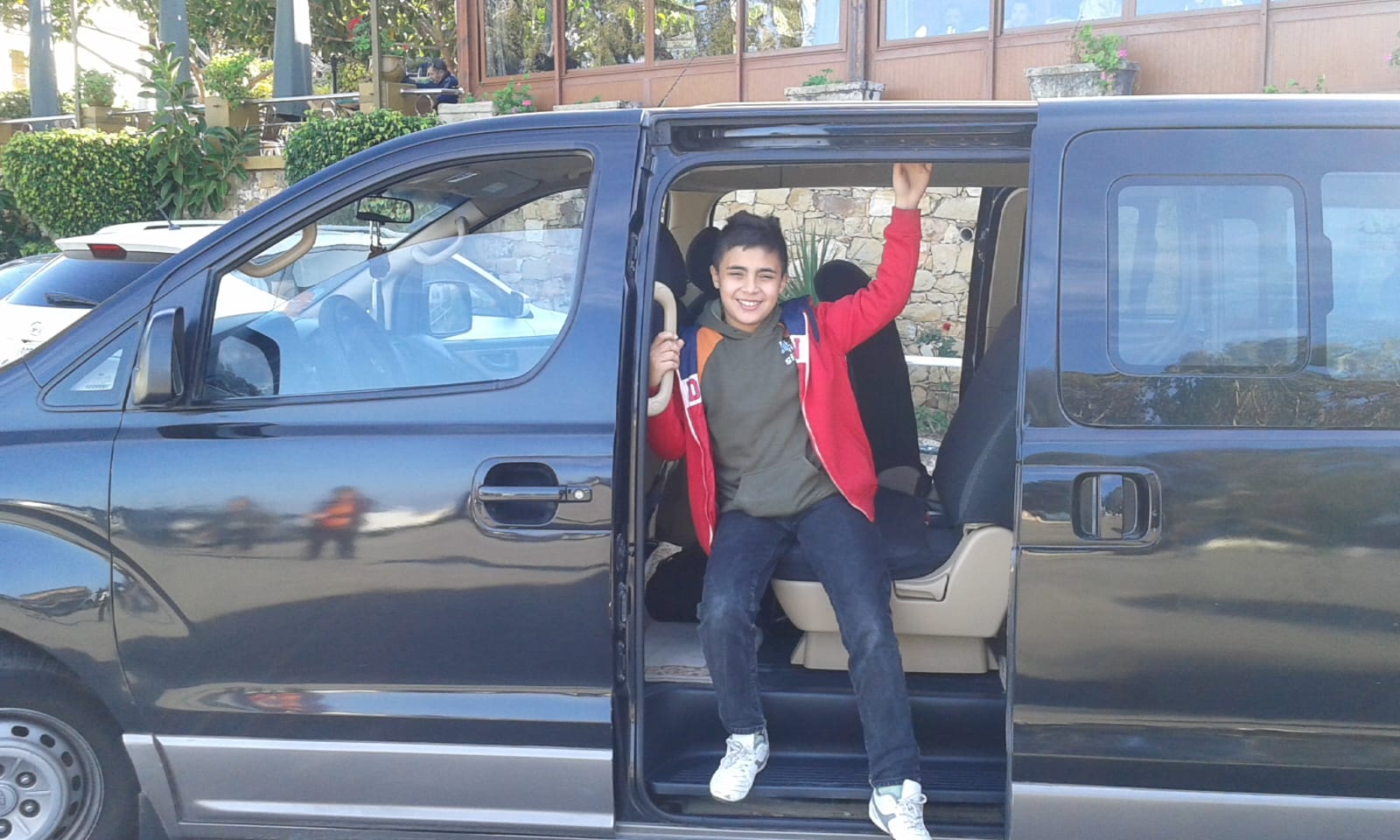 Excited child in Hamid's comfortable tour van ready for adventure