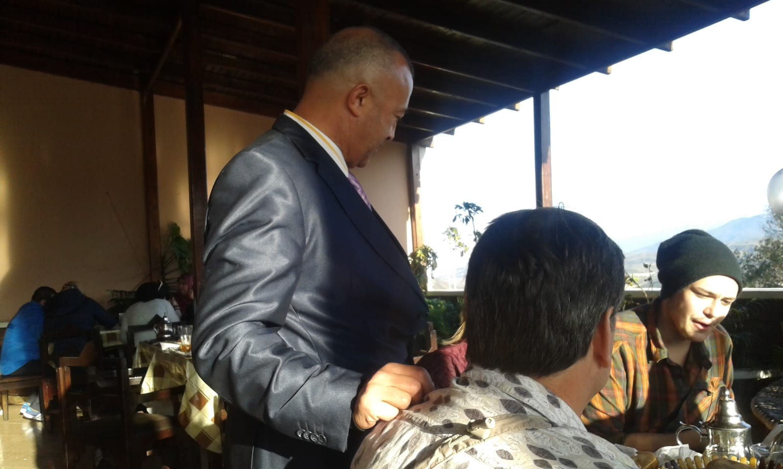 Hamid providing personalized service at a scenic mountain restaurant