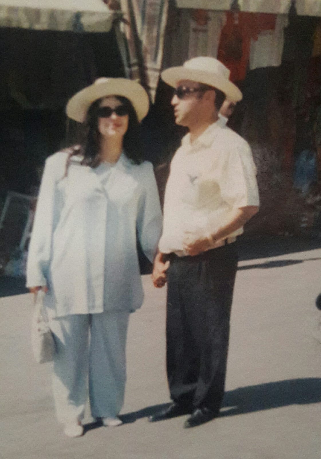 Hamid with a tourist in a vintage photo, both wearing traditional sun hats