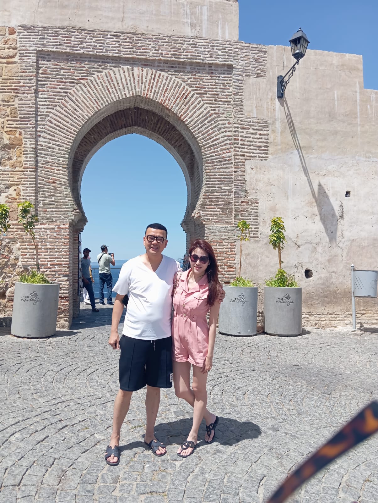 Tourists at a traditional Moroccan archway in the medina
