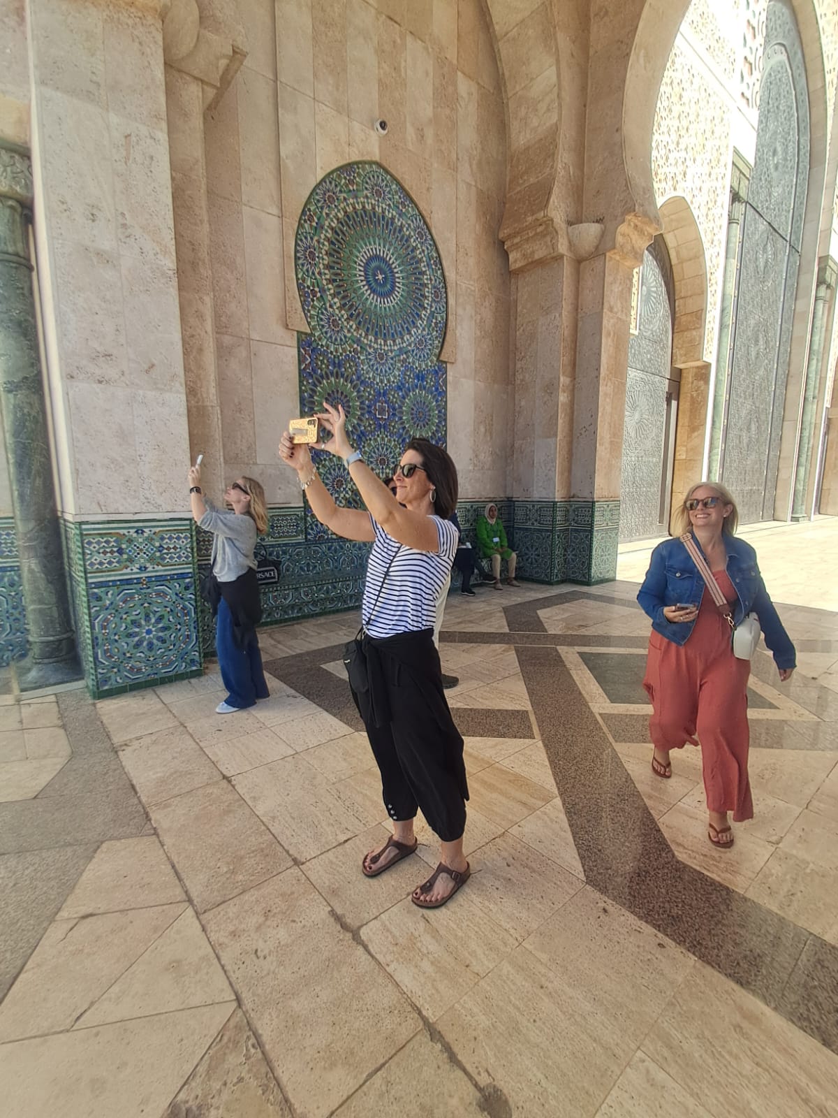 Tourists admiring the beautiful mosaic interior of a Moroccan mosque
