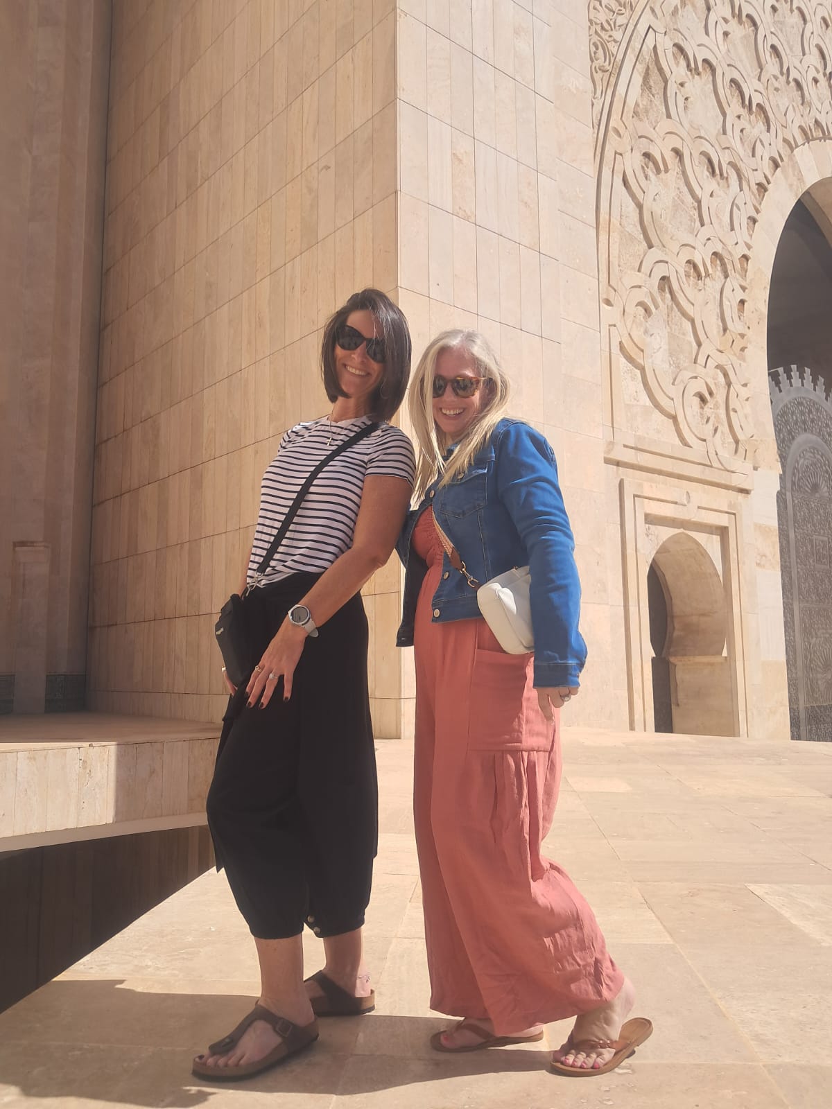 Two tourists exploring the stunning architecture of a Moroccan mosque