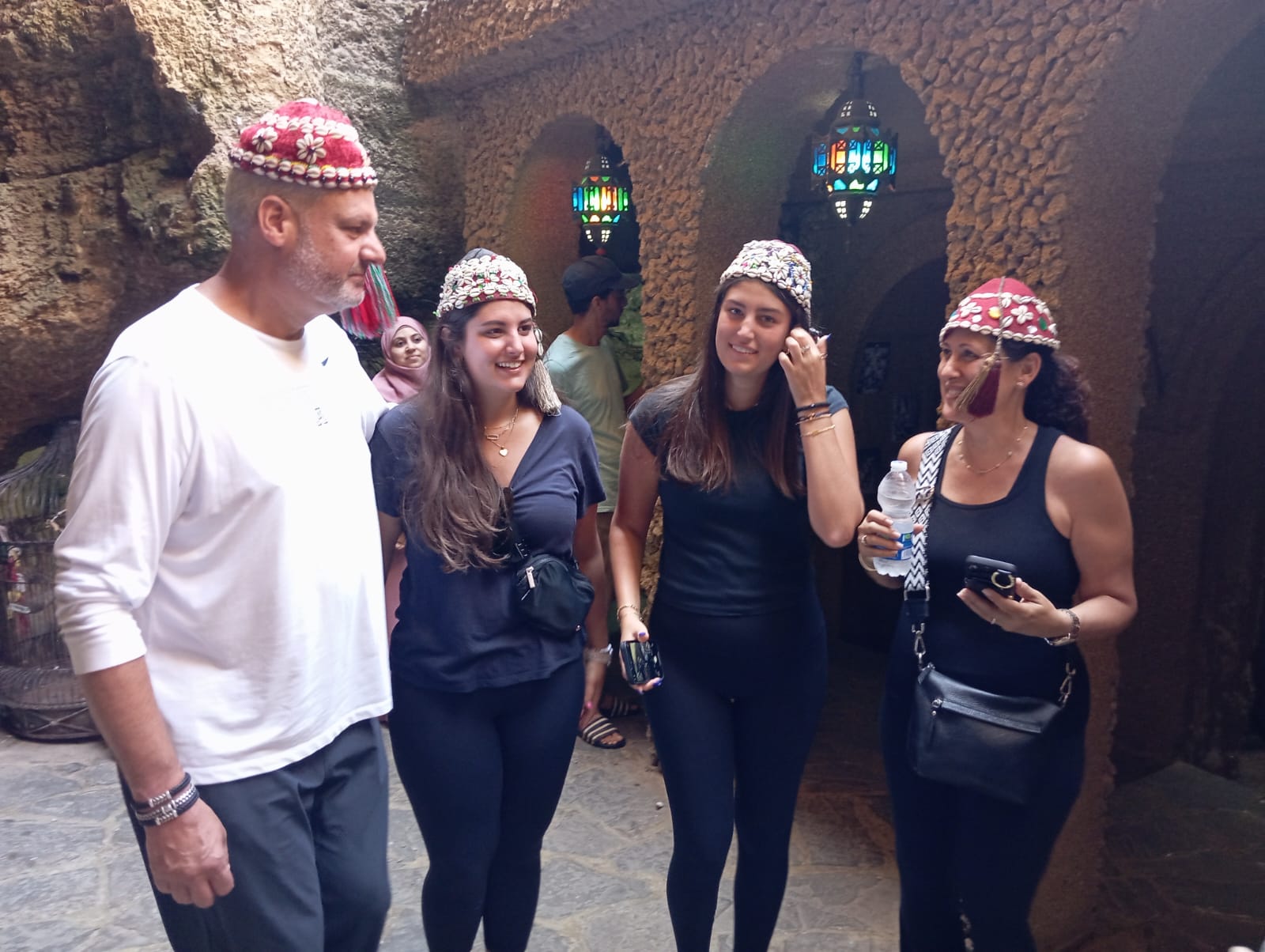 Tourists wearing traditional Moroccan hats during a cultural experience